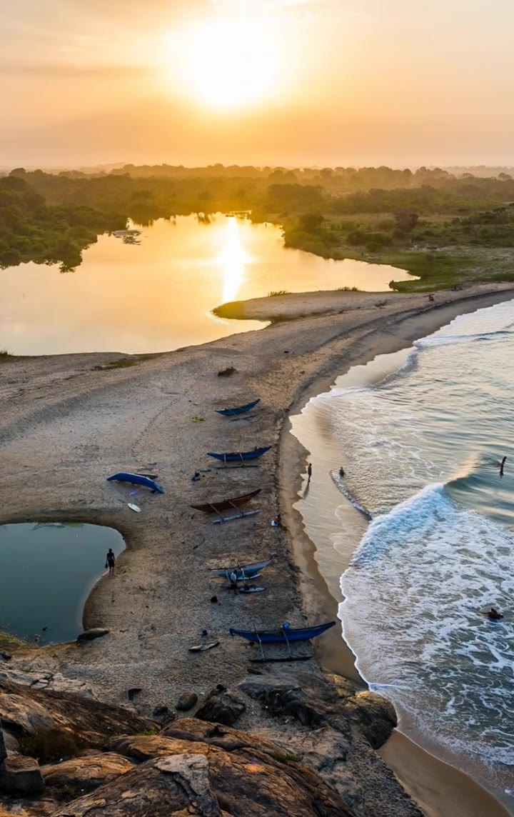 Fishing boats on the sand at sunrise beside the lagoon at Arugam Bay, Sri Lanka