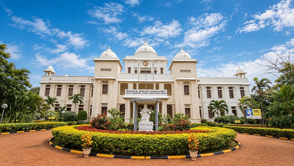 The white facade and domes of the Jaffna Public Library behind its flower beds, Sri Lanka