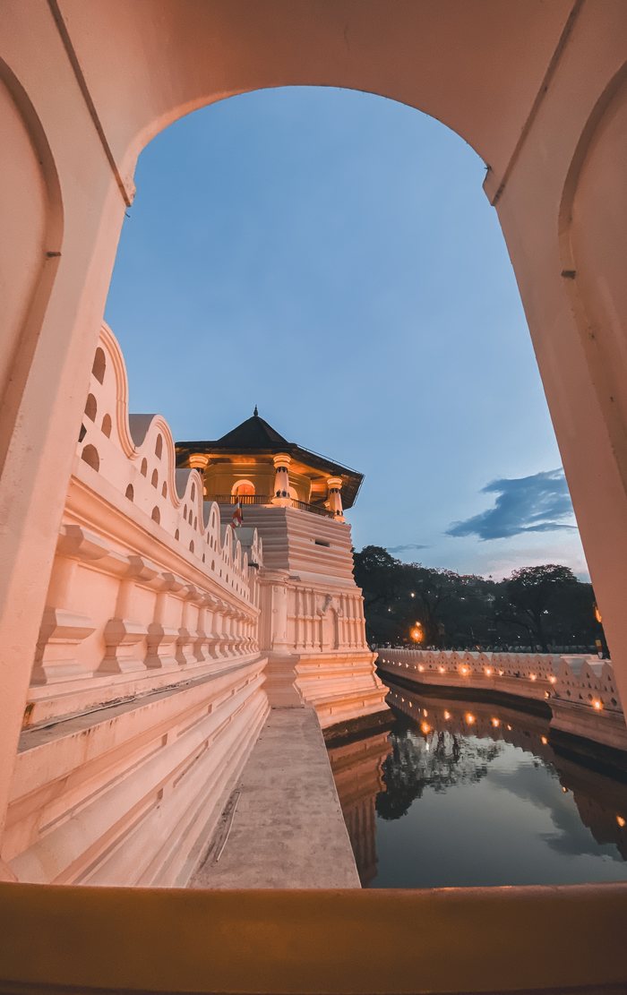 The Temple of the Sacred Tooth at dusk, seen through an archway