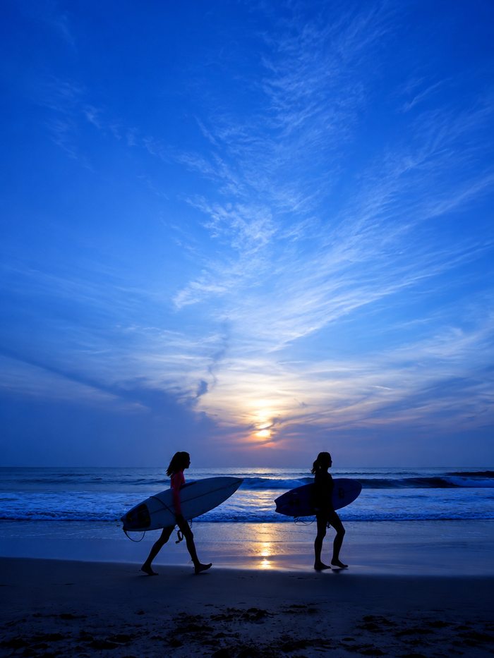 A surfer carving off the lip of a breaking wave in clear blue water, Sri Lanka