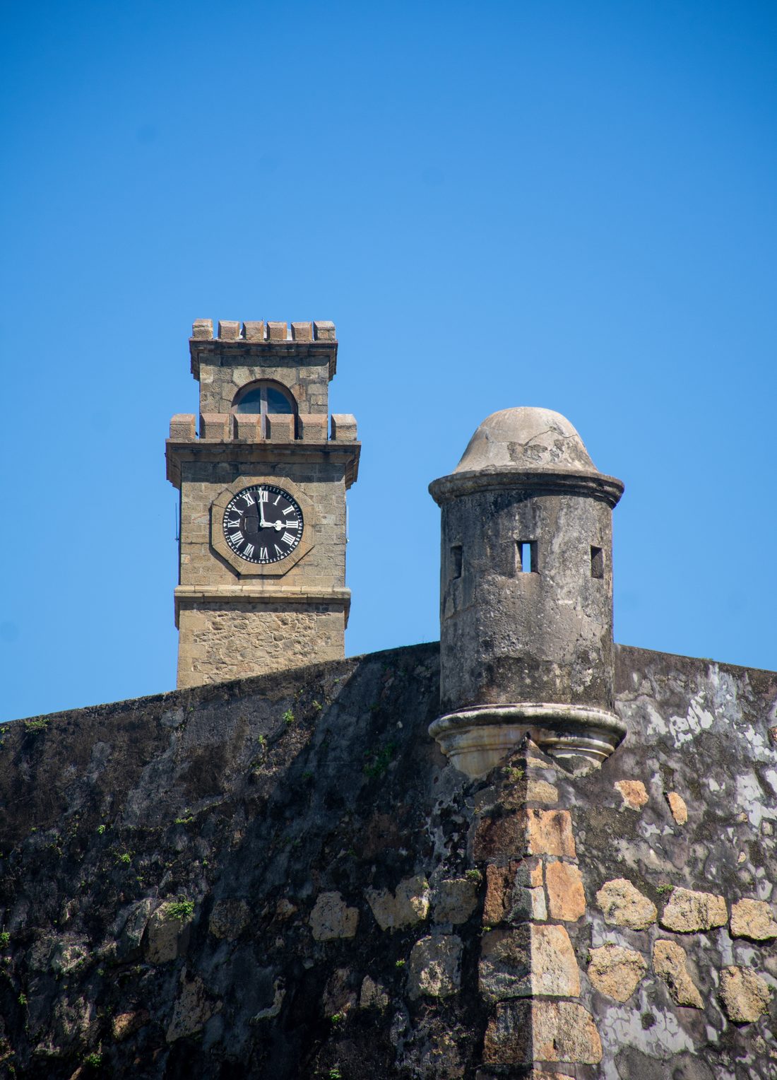 The clock tower and bastions of Galle Fort against blue sky